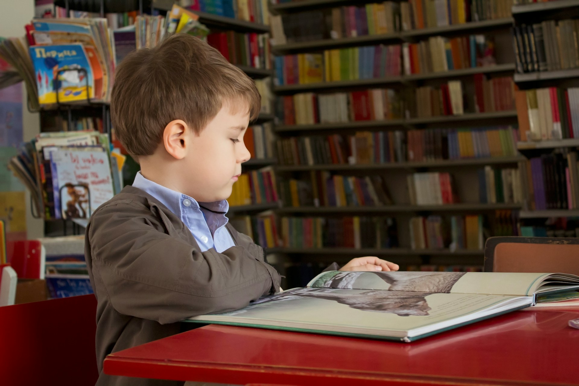 boy reading surrounded by books